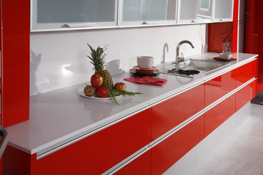 cervena kuchyne s  deskou z umeleho kamene